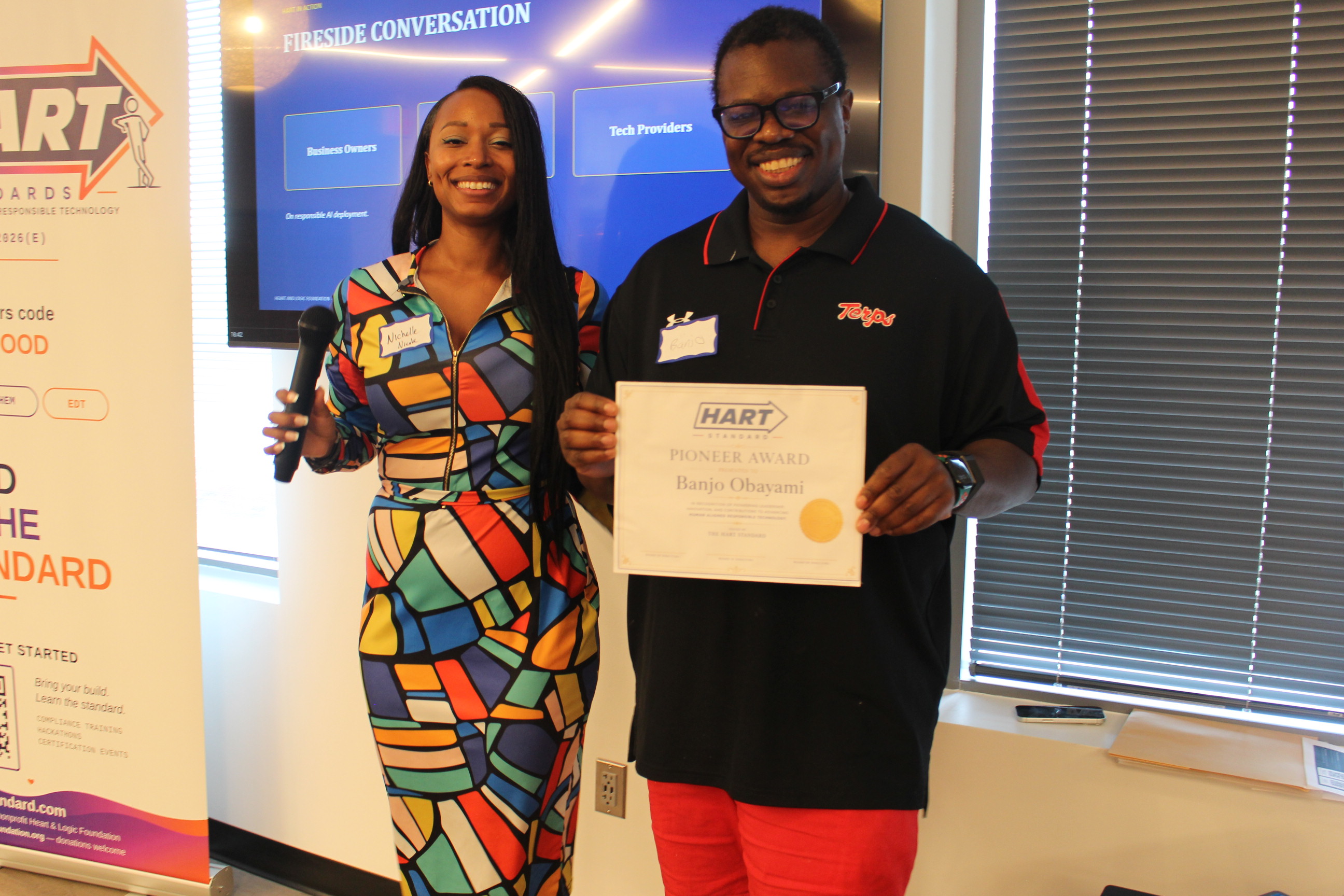 Nichelle Nicole, Founder and CEO, presenting the HART Standard Pioneer Award to Banjo Obayomi at the HART Standard unveiling